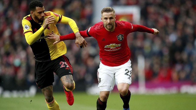 Watford's Etienne Capoue, left, and Manchester United's Luke Shaw during their English Premier League soccer match at Old Trafford in Manchester, England, Sunday Feb. 23, 2020. (Martin Rickett/PA via AP)