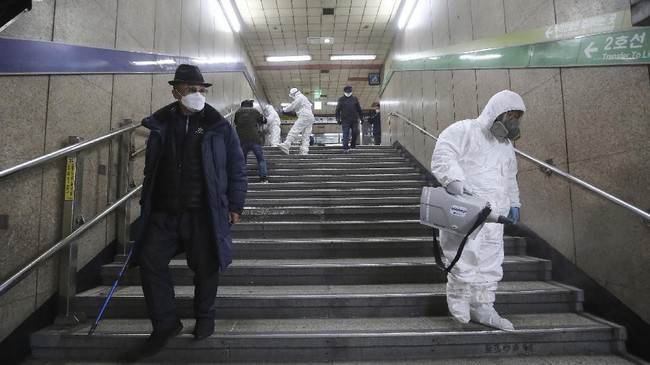 Workers wearing protective gears spray disinfectant as a precaution against the coronavirus at a subway station in Seoul, South Korea, Friday, Feb. 21, 2020. South Korea on Friday declared a "special management zone" around a southeastern city where a surging viral outbreak, largely linked to a church in Daegu, threatens to overwhelm the region's health system. (AP Photo/Ahn Young-joon)