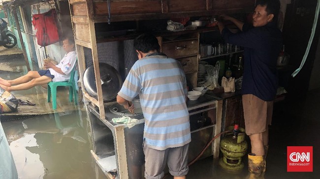 Khodirin, penjual mie ayam di kawasan Sunter, memilih tetap berjualan meski rumahnya tengah kebanjiran.