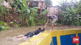 Banjir, Tanggul Baswedan Jadi Kolam Renang Bocah Jati Padang