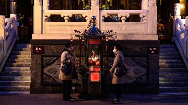 This photo taken on February 23, 2020 shows people wearing face masks as they gather at the Guandi Temple in the Chinatown district in Yokohama. - Japan has more than 130 cases of the COVID-19 coronavirus and four have died. Three of those deaths were passengers who had been on the cruise ship Diamond Princess, quarantined off in Yokohama, where the number of infections is now at 630. (Photo by Philip FONG / AFP)