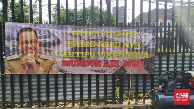 Spanduk menampilkan gambar Anies Baswedan dengan tulisan 'Banjir Kotanya, Habis APBD-nya, Tertipu Warganya. Mundur Aja deh', terbentang kawasan Menteng, Jakpus.