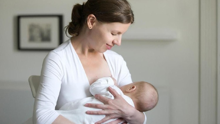 Ibu menyusui Portrait of a young attractive woman breastfeeding a child, holding on her hands, sitting. New born, bonding concept photo, horizontal