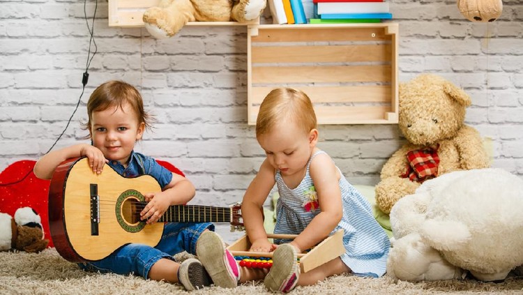 nama bayi Happy little kid, baby girl in 1 year plays a musical instrument xylophone in game center, of the children's room for birthday or home.