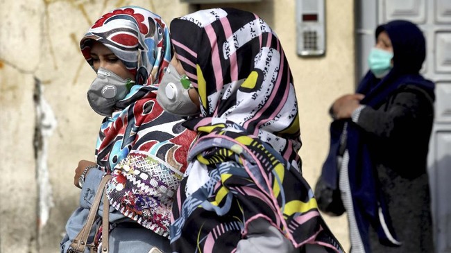 People wear masks to help guard against the Coronavirus in downtown Tehran, Iran, Sunday, Feb. 23, 2020. On Sunday Iran's health ministry raised the death toll from the new virus to 8 people in the country, amid concerns that clusters there, as well as in Italy and South Korea, could signal a serious new stage in its global spread. (AP Photo/Ebrahim Noroozi)