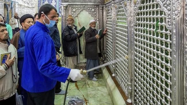 In this Monday, Feb. 24, 2020, photo, a man disinfects the shrine of Saint Masoumeh against coronavirus in the city of Qom 78 miles (125 kilometers) south of the capital Tehran, Iran. Iran's government said Monday that 12 people had died nationwide from the new coronavirus, rejecting claims of a much higher death toll of 50 by a lawmaker from the city of Qom that has been at the epicenter of the virus in the country. (Ahmad Zohrabi/ISNA via AP)
