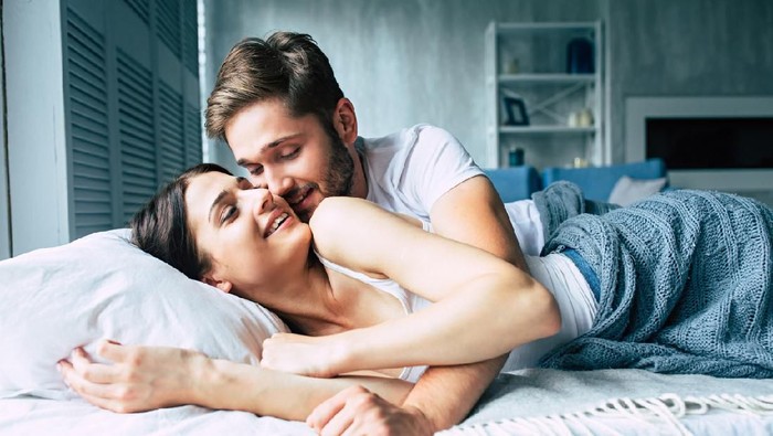 Young loving couple enjoying in their morning time and talking to each other in bedroom.