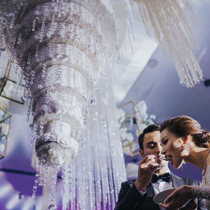 <p>Ya, mereka memilih wedding cake yang berbentuk seperti lampu kristal. Kue pernikahan mereka tampak didekor menjadi sangat cantik dan digantung di atas hall. Wajar ya, kalau pernikahannya viral seperti sekarang ini. ( Foto by @cstproduction via Instagram @zahirahmacwilson)</p>