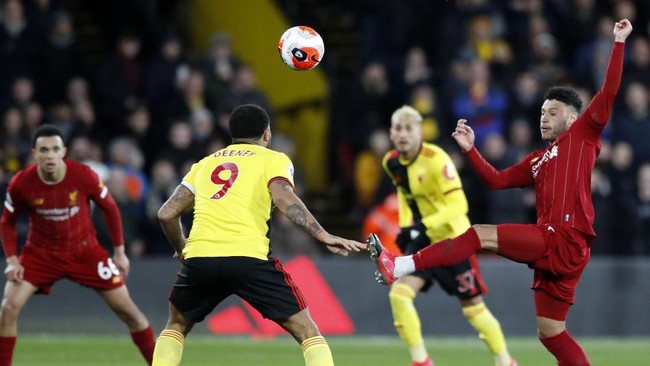 Liverpool's Alex Oxlade-Chamberlain, right, duels for the ball with Watford's Troy Deeney, center, during the English Premier League soccer match between Watford and Liverpool at Vicarage Road stadium, in Watford, England, Saturday, Feb. 29, 2020. (AP Photo/Alastair Grant)