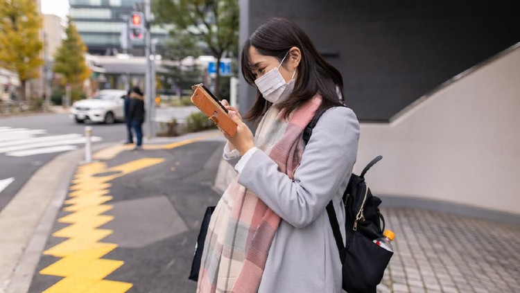 Asian pregnant Woman She is in the middle of the road Wear a PM2.5 dust mask.