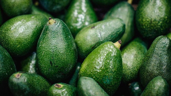 Textured many fresh, organic and green avocado fruits in full-frame background