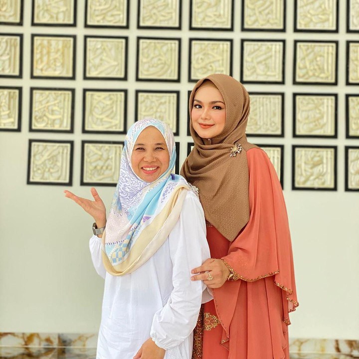 <p>Bersama para kerabat yang datang ke kondangan, mereka berpose di salah satu bangunan dengan arsitektur megah berhias huruf-huruf Arab.</p>