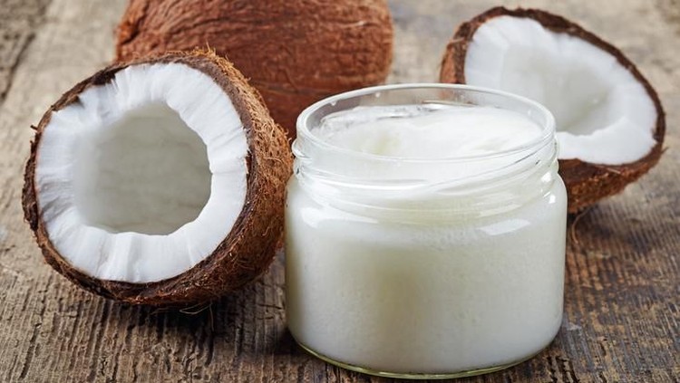 coconut oil and fresh coconuts on old wooden table