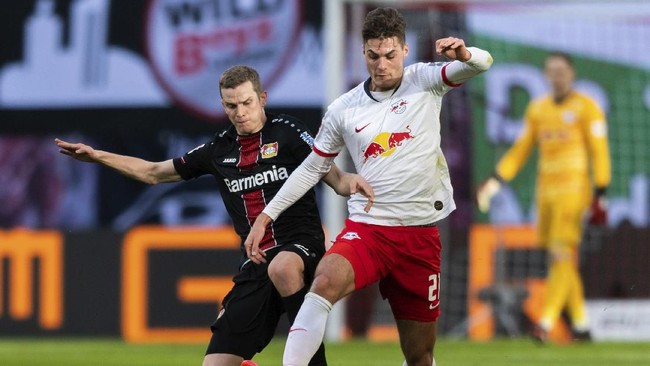 Leipzig's Patrik Schick, right, and Leverkusen's Sven Bender challenge for the ball during the German Bundesliga soccer match between RB Leipzig and Bayer Leverkusen 04 in Leipzig, Germany, Sunday, March 1, 2020. (Robert Michael/dpa via AP)