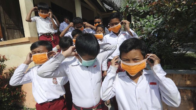 Sejumlah siswa menggunakan masker yang dibagikan oleh Badan Penanggulangan Bencana Daerah (BPBD) Kabupaten Boyolali pascaletusan gunung Merapi di SD N 1 Ringinlarik, Musuk, Boyolali, Jawa Tengah, Selasa (3/3/2020). Masker tersebut dibagikan kepada masyarakat lereng Gunung Merapi untuk melindungi saluran pernapasan dari abu vulkanik pascaletusan Gunung Merapi. ANTARA FOTO/Aloysius Jarot Nugroho/pd.