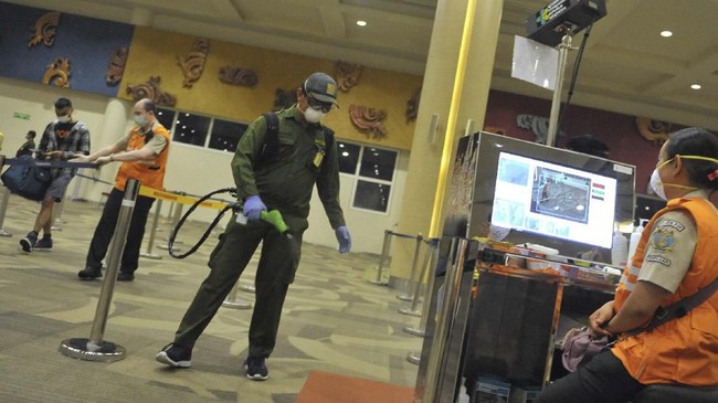 Petugas Kantor Kesehatan Pelabuhan (KKP) Kelas I Denpasar menyemprotkan cairan disinfektan di kawasan Terminal Internasional Bandara Internasional I Gusti Ngurah Rai, Bali, Selasa (3/3/2020). Kegiatan desinfeksi yang dilakukan di area terminal domestik dan internasional bandara tersebut dilakukan sebagai salah satu langkah antisipasi potensi penyebaran COVID-19 atau virus Corona. ANTARA FOTO/Fikri Yusuf/aww.