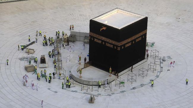 Municipal workers are pictured in empty white-tiled area surrounding the Kaaba, inside Mecca's Grand Mosque. - Saudi Arabia today emptied Islam's holiest site for sterilisation over fears of the new coronavirus, an unprecedented move after the kingdom suspended the year-round umrah pilgrimage. (Photo by ABDEL GHANI BASHIR / AFP)