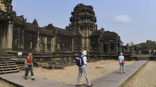Tourists visit Angkor Wat temple in Siem Reap province on March 5, 2020. - The deadly COVID-19 novel coronavirus epidemic will cost world tourism at least $22 billion owing to a drop in spending by Chinese tourists, the head of the World Travel and Tourism Council said on February 27. (Photo by TANG CHHIN Sothy / AFP)