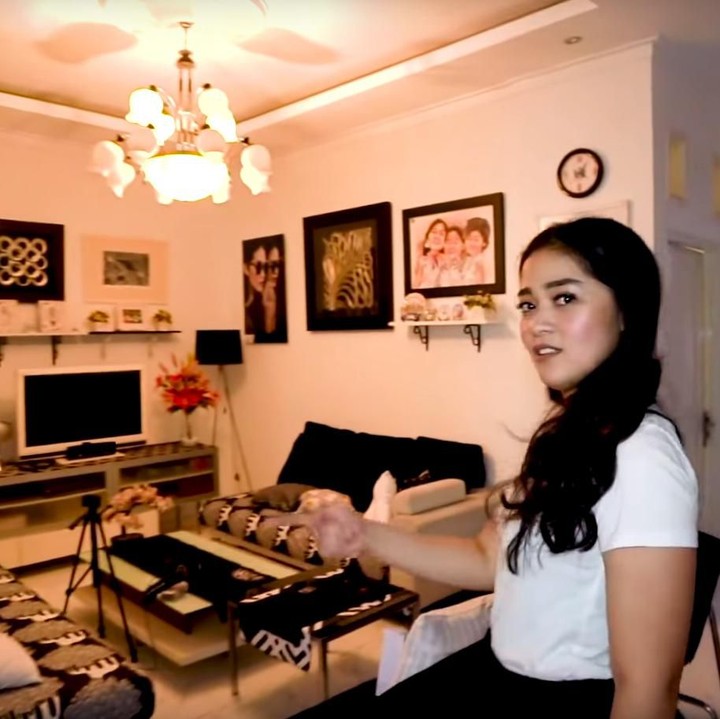 <p>Ruang keluarga rumah bernuansa monokrom, dipenuhi lukisan yang membuat ruangan terlihat elegan. (Foto: YouTube channel Adiez Gilang)</p>