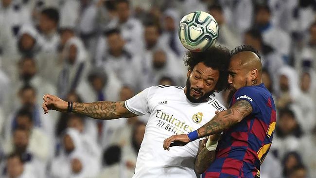 Barcelona's Chilean midfielder Arturo Vidal (R) heads the ball with Real Madrid's Brazilian defender Marcelo during the Spanish League football match between Real Madrid and Barcelona at the Santiago Bernabeu stadium in Madrid on March 1, 2020. (Photo by GABRIEL BOUYS / AFP)