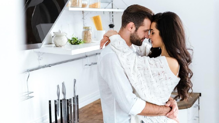 lovely gently couple embracing with closed eyes at kitchen
