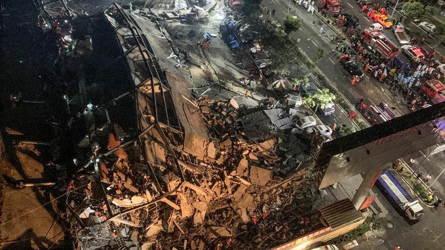 Tim penyelamat mencari korban selamat dari reruntuhan puing hotel di Quanzhou, China yang digunakan sebagai tempat karantina virus corona. Hotel ambruk pada Sabtu (7/3). (Photo by STR / AFP) / China OUT.