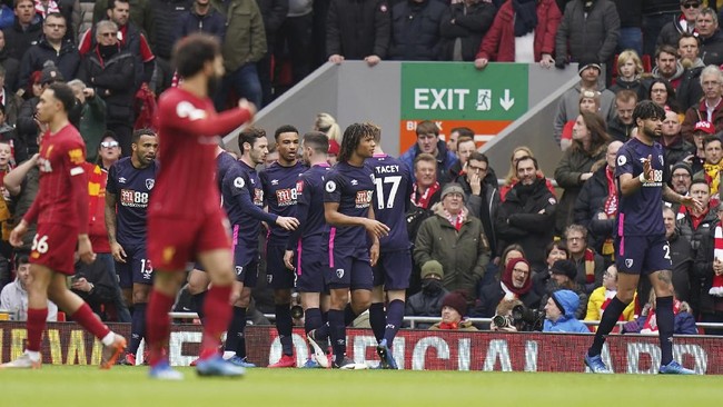 Bournemouth's Callum Wilson, covered by his teammates, celebrates after scoring his side's opening goal during the English Premier League soccer match between Liverpool and Bournemouth at Anfield stadium in Liverpool, England, Saturday, March 7, 2020. (AP Photo/Jon Super)