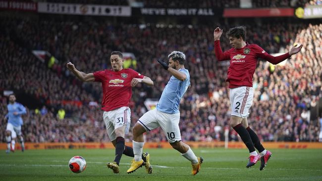 Manchester City's Sergio Aguero, center, and Manchester United's Nemanja Matic, left, and Victor Lindelof compete for the ball during the English Premier League soccer match between Manchester United and Manchester City at Old Trafford in Manchester, England, Sunday, March 8, 2020. (AP Photo/Dave Thompson)