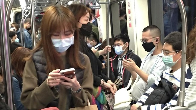 People wear face masks to protect against the spread of the coronavirus on MRT in Taipei, Taiwan, Saturday, March 7, 2020. (AP Photo/Chiang Ying-ying)