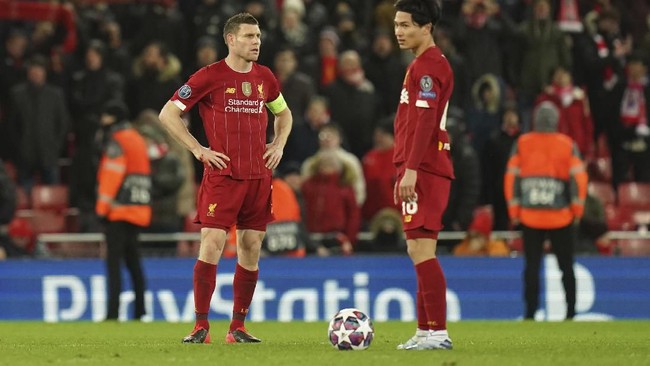 Liverpool's James Milner, left, and Liverpool's Takumi Minamino stand in dejection after Atletico Madrid's Alvaro Morata scores his side's third goal during a second leg, round of 16, Champions League soccer match between Liverpool and Atletico Madrid at Anfield stadium in Liverpool, England, Wednesday, March 11, 2020. (AP Photo/Jon Super)