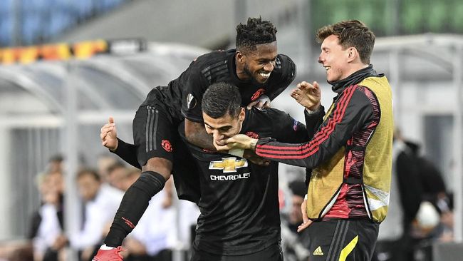 APTOPIX Austria Soccer Europa League Virus Outbreak Manchester United's Fred jumps on Manchester United's scorer Andreas Pereira who scored his side's 5th goal during the Europa League round of 16 first leg soccer match between Linzer ASK and Manchester United in Linz, Austria, Thursday, March 12, 2020. The match is being played in an empty stadium because of the coronavirus outbreak. (AP Photo/Kerstin Joensson)
