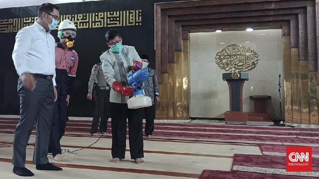 Gubernur Jabar Ridwan Kamil bersama Penceramah Aa Gym menyemprotkan disinfektan di Masjid Al-Mutaqien Provinsi Jabar, Kamis (19/3).