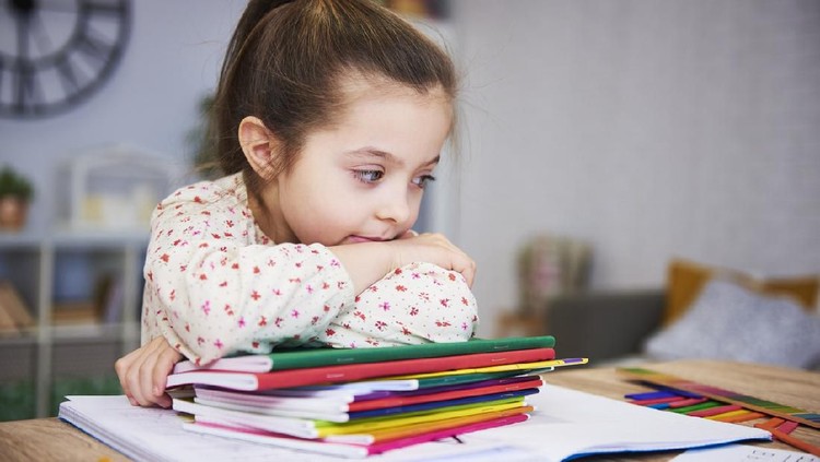 Tired and bored student with stack of books