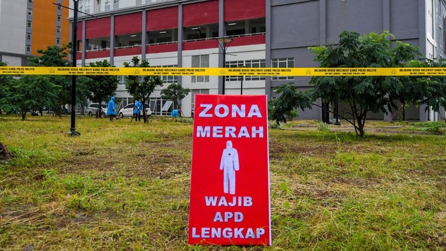 Petugas melintas di depan tower tujuh RS Darurat Covid-19, kompleks Wisma Atlet di Kemayoran, Jakarta, Minggu (22/3/2020). Pemerintah menyiapkan 2.500 kamar tidur di tower enam dan tujuh Wisma Atlet yang digunakan sebagai RS Darurat Covid-19 untuk penanganan pasien Covid-19. ANTARA FOTO/Galih Pradipta/foc.