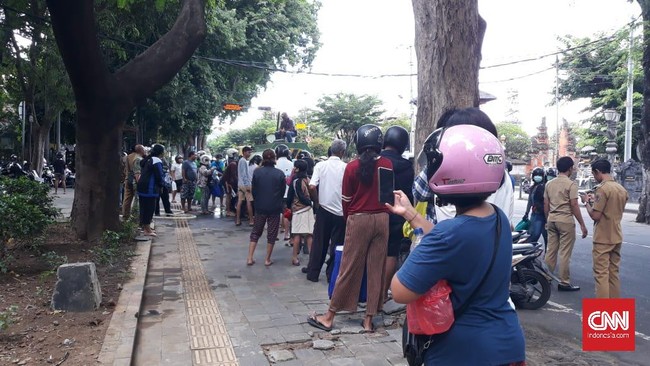 Warga di Denpasar, Bali berkerumun untuk mendapatkan disinfektan gratis yang dibagikan Pemkot Denpasar, Senin (23/3).