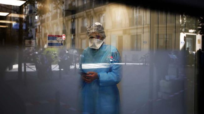 Virus Corona di Prancis Biologist doctor Caroline Gutsmuth gives a phone call in medical biology laboratory who opened a coronavirus drive-thru testing site, in Neuilly-sur-Seine, near Paris, Monday, March 23, 2020. French President Emmanuel Macron urged employees to keep working in supermarkets, production sites and other businesses that need to keep running amid stringent restrictions of movement due to the rapid spreading of the new coronavirus in the country. For most people, the new coronavirus causes only mild or moderate symptoms. For some it can cause more severe illness, especially in older adults and people with existing health problems. (AP Photo/Christophe Ena)