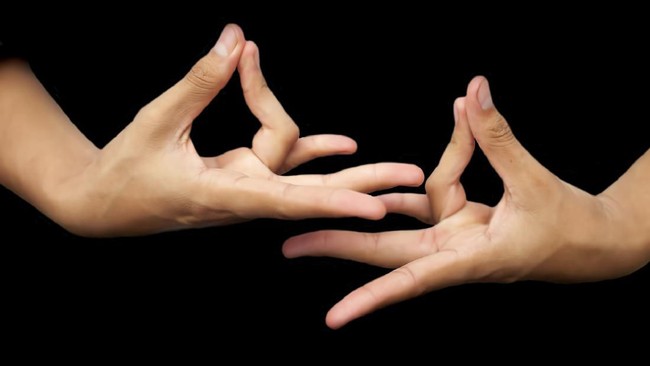 Isolated hands of male teenager doing or practicing Prithvi Yoga Mudra or Earth posture horizontal shot. Joining ring finger to thumb and forming Prithvi Mudra.