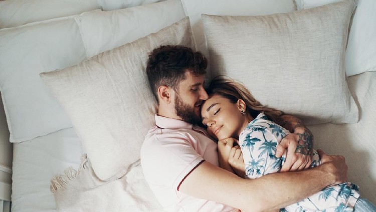 couple Couple in love is embracing on the bed. Man hugging and kissing his girlfriend. Top view