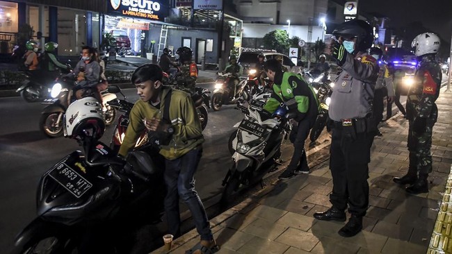 Petugas gabungan TNI, Polri dan Satpol PP membubarkan warga yang masih berkumpul saat melakukan razia cegah penyebaran COVID-19 di kawasan Kemang, Jakarta, Selasa (24/3/2020). Dalam razia tersebut petugas meminta warga untuk tidak berkumpul dalam keramaian dan dihimbau untuk pulang ke rumah masing-masing sesuai instruksi pemerintah agar melakukan 