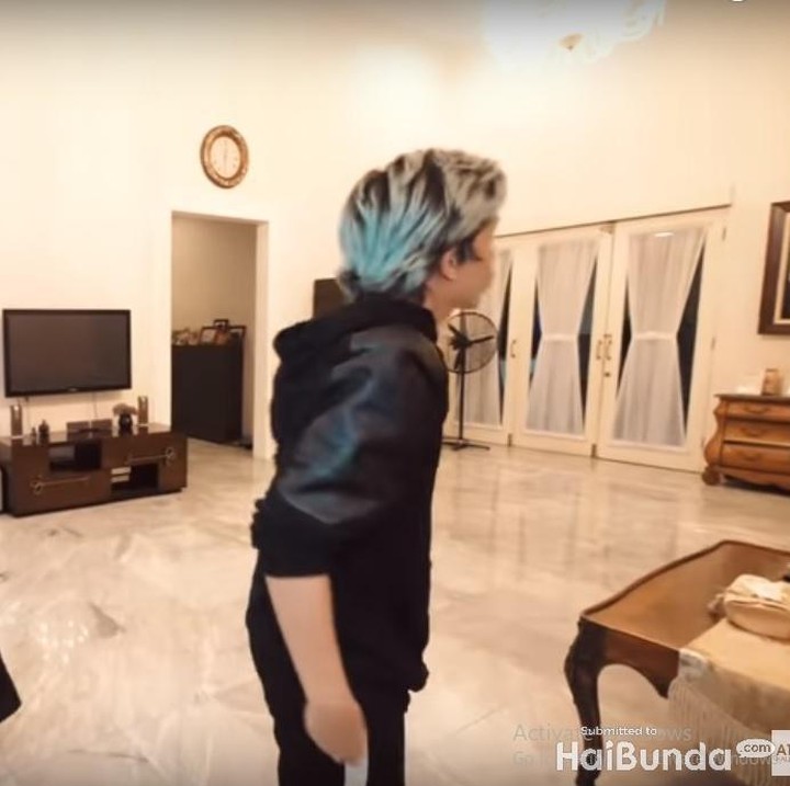 <p>Ruang pertama yang Bella kenalkan adalah ruang tamunya yang terlihat luas. Bella mengakui tidak memiliki konsep khusus, namun baginya cukup untuk terlihat nyaman dengan menyelaraskan motif pada tembok dengan bantal sofa yang ada di sana. (Foto: Youtube Atta Halilintar)</p>
