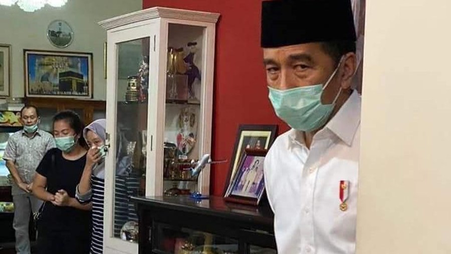 Tertunduk lesu, Presiden Jokowi duduk termenung di hadapan jenazah sang ibunda.