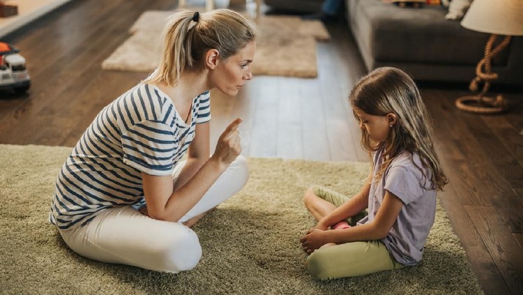 1063759978 Angry offended little girl ignoring not listening mother words, advice, mum hugging, talking with stubborn, upset daughter at living room, bad upbringing, difficult behavior of child
