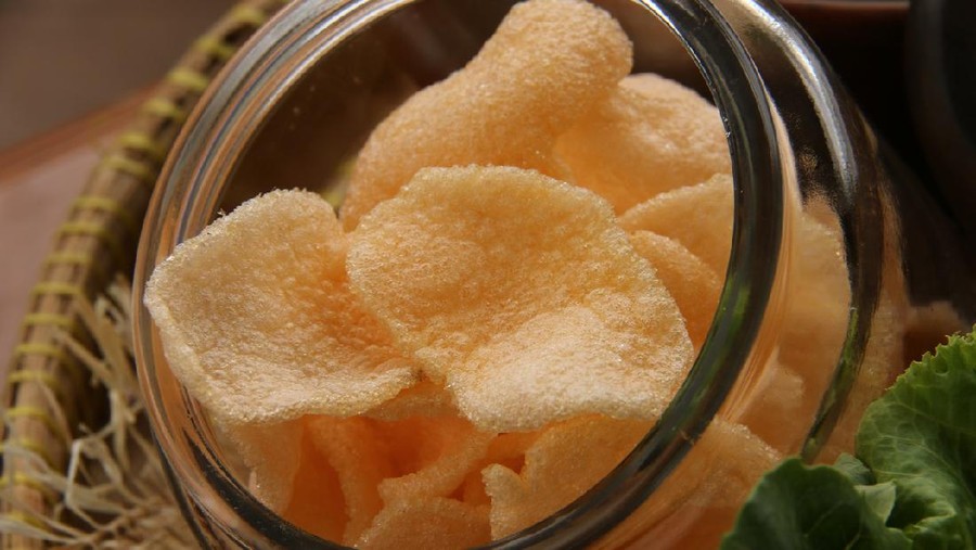 Kerupuk udang, Indonesian shrimp cracker crisps that commonly served with many Indonesian dishes such as Nasi Uduk. The crackers are deep-fried and then stored in a transparent glass jar. Here the jar is placed on a traditional bamboo tray, together with other accompaniments for Nasi Uduk.