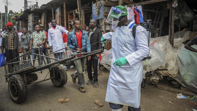 A Kenyan Health Ministry official sprays disinfectant onto a hand-cart to control the spread of the new coronavirus, in the Gikomba outdoor street market in the capital Nairobi, Kenya Saturday, March 21, 2020. For most people, the new coronavirus causes only mild or moderate symptoms such as fever and cough and the vast majority recover in 2-6 weeks but for some, especially older adults and people with existing health issues, the virus that causes COVID-19 can result in more severe illness, including pneumonia. (AP Photo/John Muchucha)