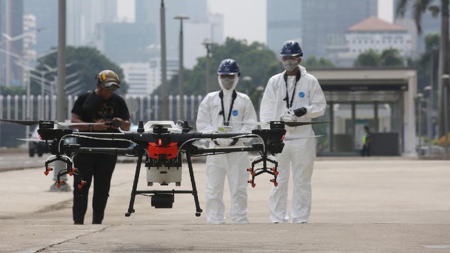 Petugas menyiapkan drone yang digunakan untuk meyemrotkan disinfektan di kawasan Jalan Jenderal Sudirman, Jakarta, Jumat (27/3/2020). Penyemprotan disinfektan tersebut dilakukan guna menekan penyebaran virus Corona (COVID-19). ANTARA FOTO/Reno Esnir/nz.