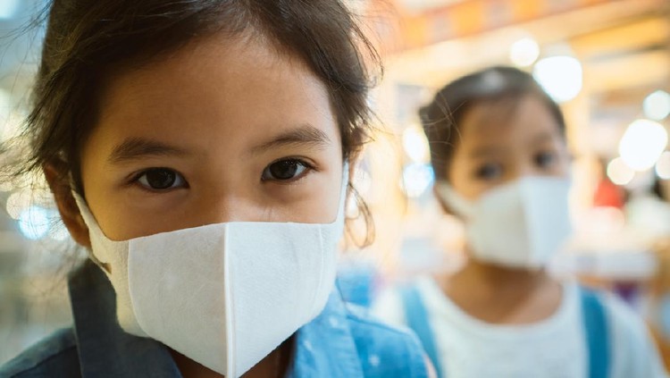 Cute asian child girl wearing protection mask to against air smog pollution with PM 2.5 in the city