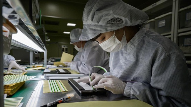 Staff members prepare diagnostic components to be used in COVID-19 novel coronavirus testing kits on a production line at the SD Biosensor bio-diagnostic company near Cheongju, south of Seoul on March 27, 2020. - SD Biosensor is one of five companies in South Korea -- which appears to have brought its epidemic under control with a huge 