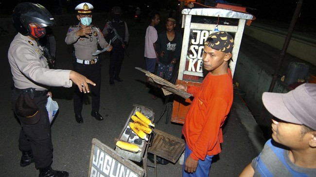 Petugas kepolisian membubarkan warga yang berkumpul di pinggir jalan di Slawi, Kabupaten Tegal, Jawa Tengah, Sabtu (28/3/2020) malam. Patroli gabungan Polres Tegal dan Satpol PP itu guna memberikan imbauan dan menertibkan warga yang berkerumun guna antisipasi penyebaran COVID-19. ANTARA FOTO/Oky Lukmansyah/pras.