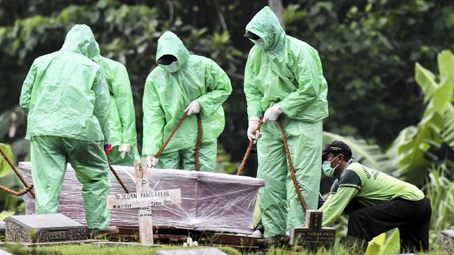 Petugas pemakaman membawa peti jenazah pasien COVID-19 di TPU Pondok Ranggon, Jakarta, Senin (30/3/2020). Juru bicara pemerintah untuk penanganan COVID-19 Achmad Yurianto per Senin (30/3/2020) pukul 12.00 WIB menyatakan jumlah pasien positif COVID-19 di Indonesia telah mencapai 1.414  kasus, pasien yang telah dinyatakan sembuh sebanyak 75 orang, sementara kasus kematian bertambah delapan orang dari sebelumnya 114 orang menjadi 122 orang. ANTARA FOTO/Muhammad Adimaja/foc.