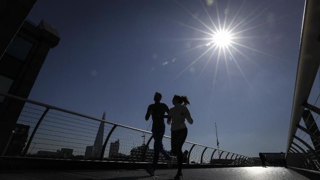 People run on Millenium Bridge over the River Thames in London, March 22, 2020. (AP Photo/Kirsty Wigglesworth)